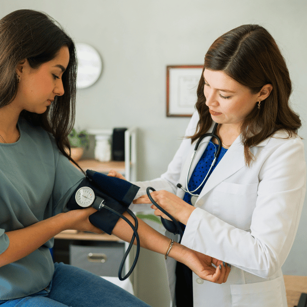 Doctor taking blood pressure and explaining what is postpartum preeclampsia